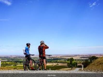 A person and person on bikes looking at a landscape

Description automatically generated
